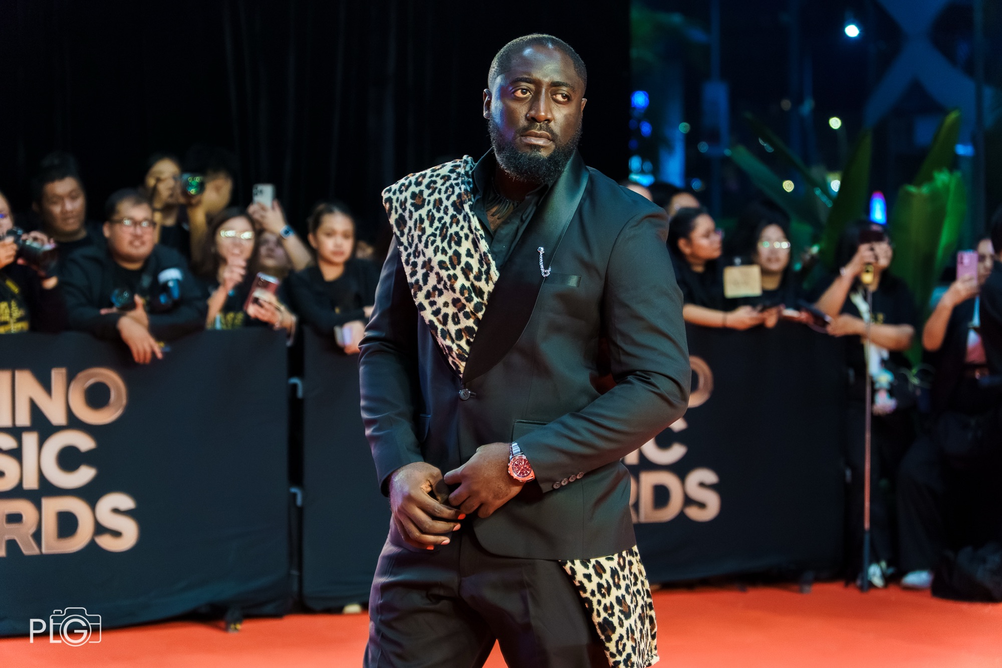 WestCoast Wind, Afrobeats artist from Cameroon, on the Filipino Music Awards red carpet in a black suit with a leopard-print sash